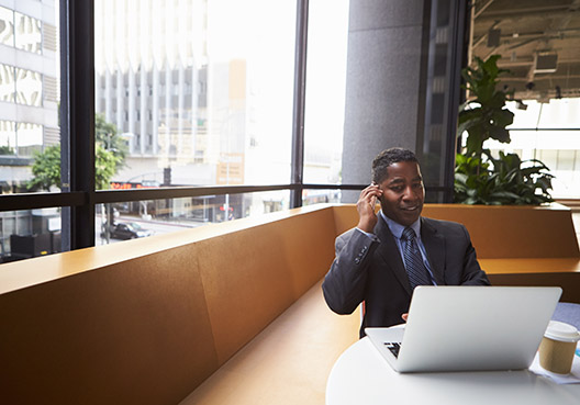Man sitting in his office on a cell phone
