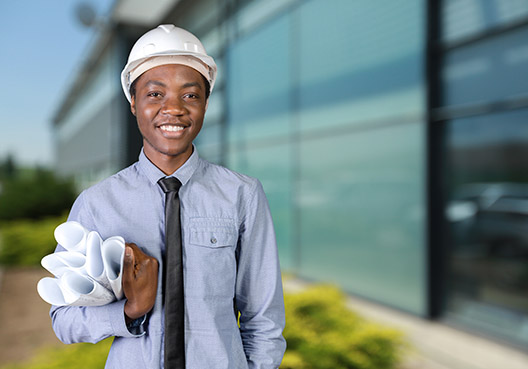 Man with safety helmet standing in front of building