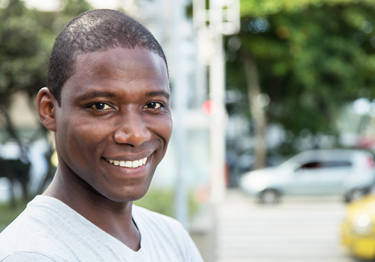 young guy smiling and looking at the camera