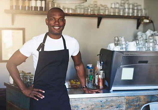 man leaning against a coffee counter